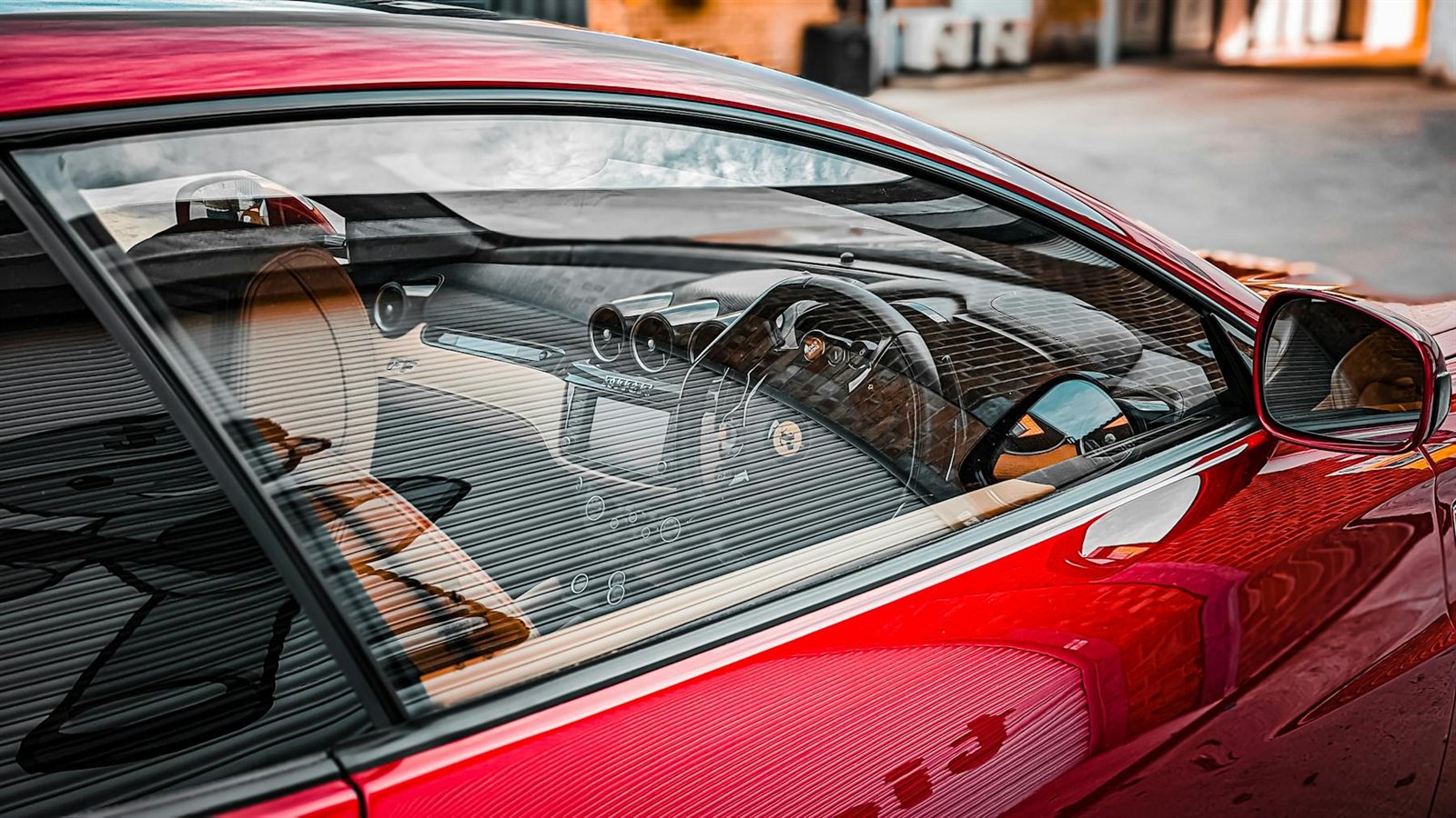 Red Ferrari side glass revealing the driver cockpit