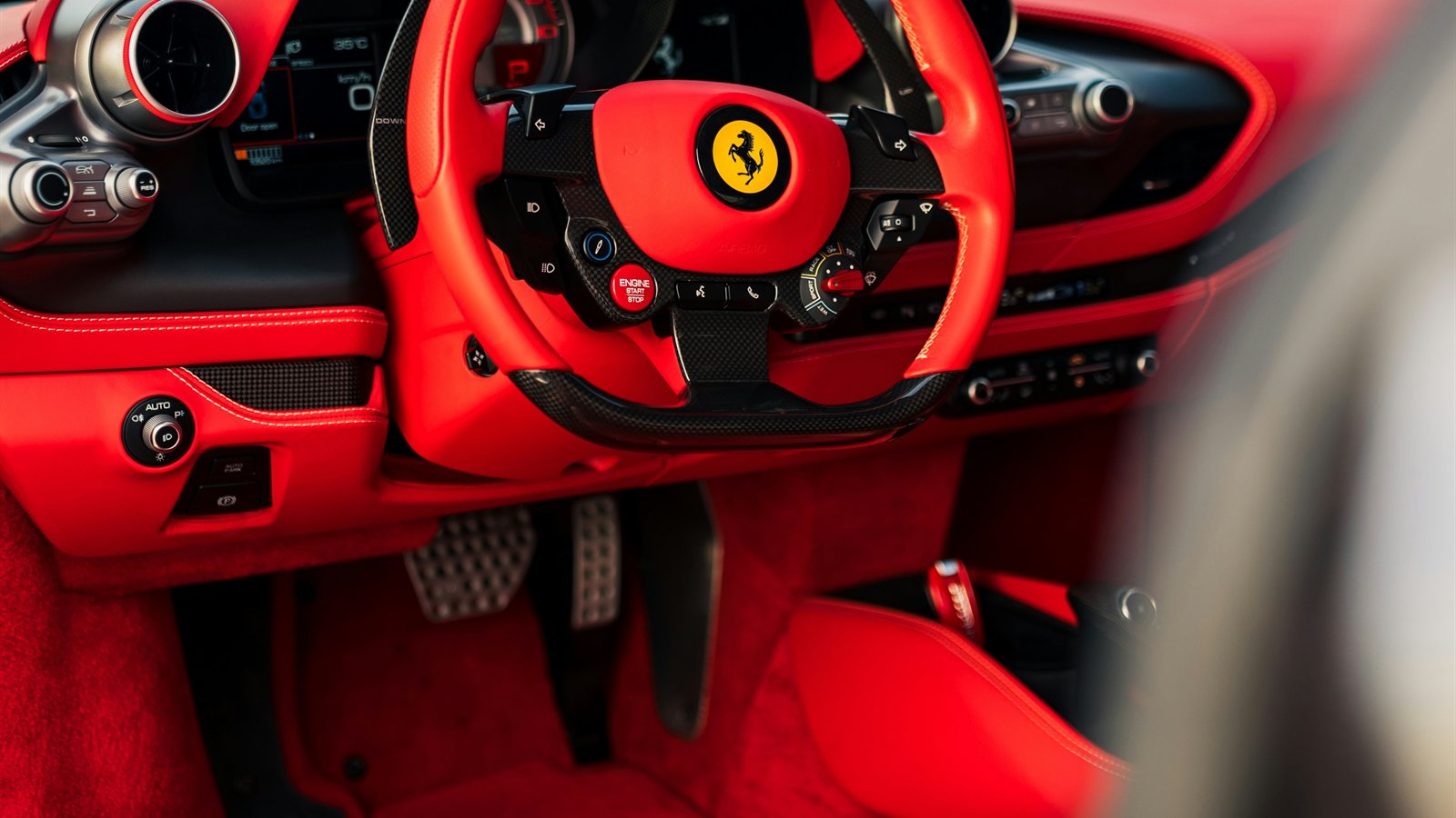 Ferrari red leather cockpit with steering wheel and seat detail